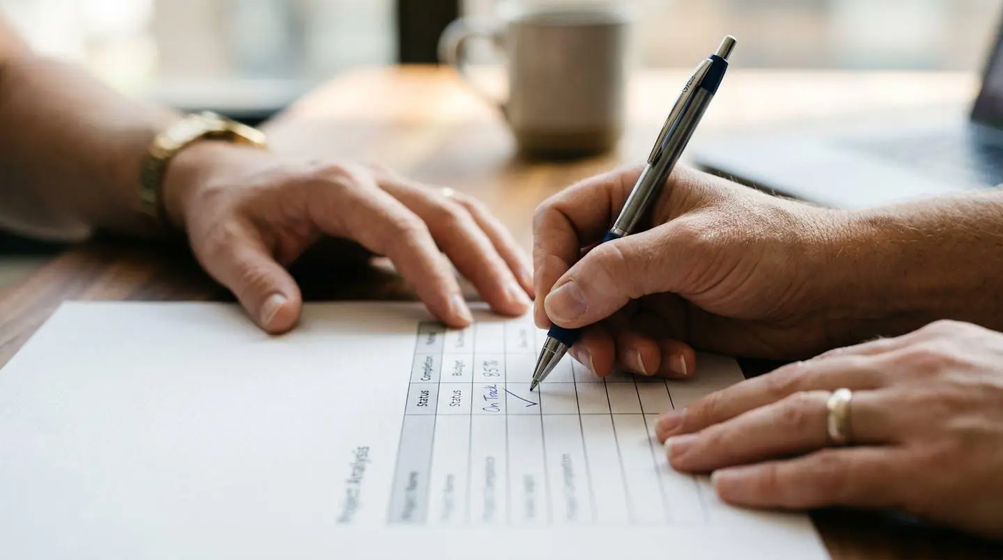 Gros plan sur des mains remplissant une grille d'analyse de projet avec un stylo, texture papier moderne, bokeh flou en arrière-plan